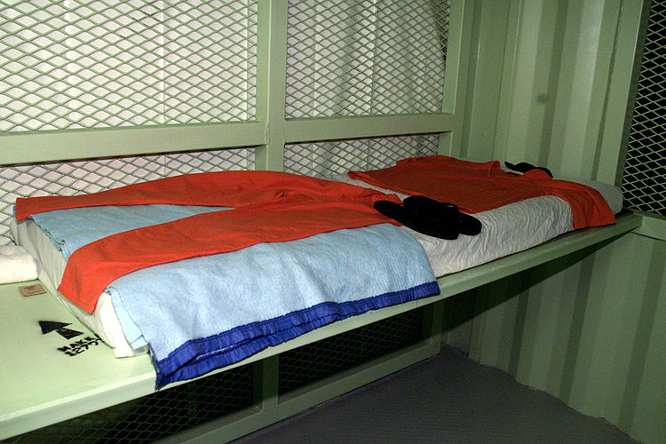 Comfort items issued to detainees at Camp Delta, Guantanamo Bay, Cuba, include: a copy of the Koran, a mattress, sheet, blanket, prayer mat, two-piece suit, flip-flop shoes, prayer cap, wash cloth and towel, and a salt packet for seasoning food. Note the arrow pointing to Mecca. Comfort items 021203-A-7236L-009.jpg