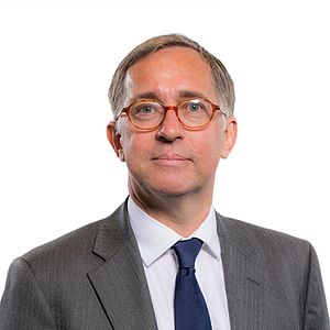 The official portrait of David Melding taken at the Senedd in 2016. He is wearing a suit, tie, and glasses.