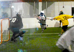 Columbus Brew player (white) sails past Detroit Coney Dogs' Owen Blank (yellow) as he attempts a dive shot on Coney Dogs goalie Devan Mighton (black) during 2012 season. Detroit-vs.-Columbus-CILL-2012 2.jpg