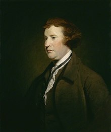 Near-profile, half-length portrait of a man wearing a brown suit who has reddish-brown hair and a ruddy complexion.