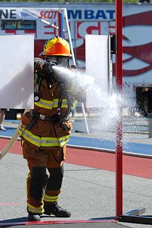Hose Advance- Competitor releasing the nozzle to spray target once through the swinging doors FFCC Hose Advance.jpg