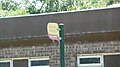 English: A bus stop in Afton Road, Freshwater, Isle of Wight, outside the Honnor & Jeffrey garden centre and End of the Line cafe. This stop is served by Southern Vectis school services, although it had been used by route 11 until that service was withdrawn. This is the west bound stop, for services towards Freshwater village centre.