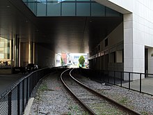 A twice-proposed commuter rail stop at Kendall Square would be located under the MIT Brain and Cognitive Science building; this location was also a proposed stop on the Urban Ring service. Grand Junction Railroad under McGovern Institute, August 2015.JPG