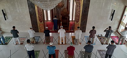 Muslims in Indonesia pray in congregation while imposing to strict protocols during the global pandemic. Physical distancing and the wearing of masks in public is mandatory in Indonesia during the COVID-19 outbreak, including in places of worship. Islamic Congregational Prayer with Physical Distancing during the Covid-19 Pandemic.jpg