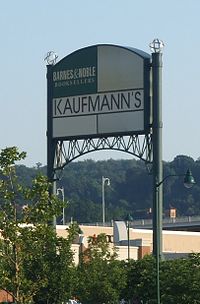 Though converted a year prior to this image's creation, this Macy's store located at The Waterfront still had Kaufmann's signage. The current Macy's sign can be seen slightly behind the trees. Macy's has since put a sign over this, but Kaufmann's is still readable beneath. This Macy's closed in 2018. Kaufmanns2007.JPG