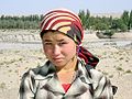A Uyghur woman from the Xinjiang province of China wears a scarf in the popular 'Italian' fashion, with the ends tied behind her head.