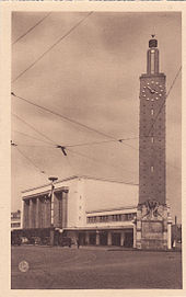 Postal en formato vertical con el edificio de pasajeros y la torre del reloj de la estación Henri Pacon