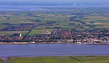 Abbehausen (links von der Bildmitte) zwischen Nordenham im Vordergrund und dem Jadebusen im Hintergrund