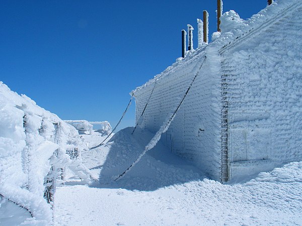 The original weathered shingle-clad building is chained to the ground, here covered in rime ice in early April.