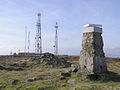 Looking east from summit, towards the cairn, two telecommunications masts and helipad