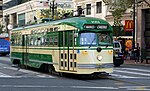 Streetcar No. 1051 of the San Francisco Municipal Railway in 2017. The streetcar is painted green and cream.