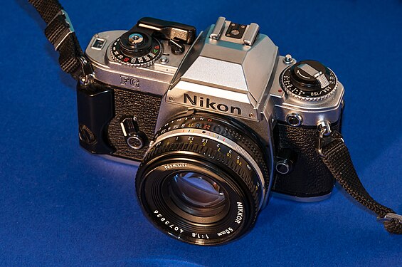 Nikon FG Kamera mit 50mm Nikkor Objektiv auf blauem Hintergrund