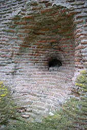 Vista di una cavità realizzata in una massa di mattoni che mostra, in basso, un'anima in pietra.