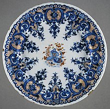 Polychrome style rayonnant lambrequin decoration, with a chinoiserie central scene. Made c. 1710, this is an early example in all these respects; 23.97 cm. Plate LACMA M.2010.51.3 (1 of 2) (cropped).jpg