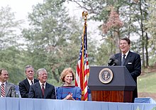 Ronald Reagan speaking at the dedication of the Jimmy Carter Presidential Library and Museum as the Carters look on, 1 October 1986 President Ronald Reagan at the dedication ceremony of the Jimmy Carter Presidential Library.jpg