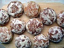 An image of 11 circular pryaniks on a wooden cutting-board.