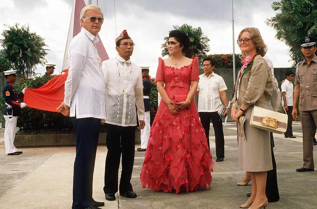 Stephen W. Bosworth, left,  US Ambassador to the Philippines, talks with President Ferdinand Marcos  and his wife Imelda during the reenactment of General Douglas  MacArthur's landing at Red Beach on October 20, 1944. Ambassador  Bosworth's wife is on the right. VIRIN: DF-ST-85-06923. | Photo from "Stephen W. Bosworth with Ferdinand & Imelda Marcos in Leyte 1984-10-20" by Wikimedia Commons is in the Public Domain 