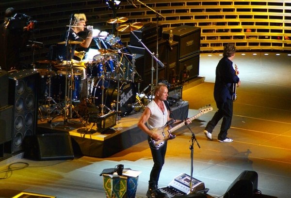 Andy Summers (far right), Sting (front), Stewart Copeland (drums). The Police performing at Madison Square Garden on 1 August 2007.