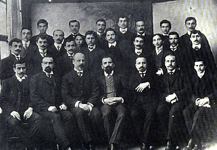Three rows of Pontic Greek men in western suits, standing or seated close together.