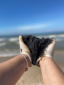 גוש זפת שהורם בידי מתנדבת לניקוי החופים בחוף ניצנים, 20 בפברואר 2021