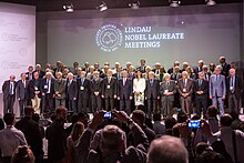 Group shot of the 65 Nobel Laureates who attended the 65th Lindau Nobel Laureate Meeting in summer of 2015 and German President Joachim Gauck as well as Countess Bettina Bernadotte, President of the Council for the Lindau Nobel Laureate Meetings 65th Lindau Nobel Laureate Meeting (2015).jpg