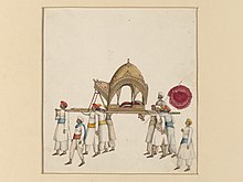 A covered sedan chair being carried by eight or nine men, wearing white with various coloured sashes and turbans. A covered sedan chair being carried by eight or nine men, wearing white with various coloured sashes and turbans.jpg