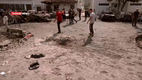 Clockwise from top:  A man carries the body of a Palestinian child killed during the shelling of 17 October 2023 The impact crater Aftermath of Al-Ahli Arab Hospital explosion 