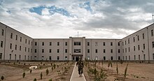 Bir Afgan Ulusal Savunma Üniversitesi (ANDU) eğitmeni, 7 Mayıs 2013, Kabil, Afganistan'daki okulun akademik salonundan çıkıyor, 130507-F-OF869-007.jpg