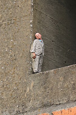 Statuette d'Isaac Cordal nichée dans une cheminée (voie des Hennuyers).