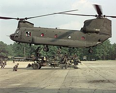 Soldiers sling loading a howitzer onto an army CH-47 helicopter, 2015