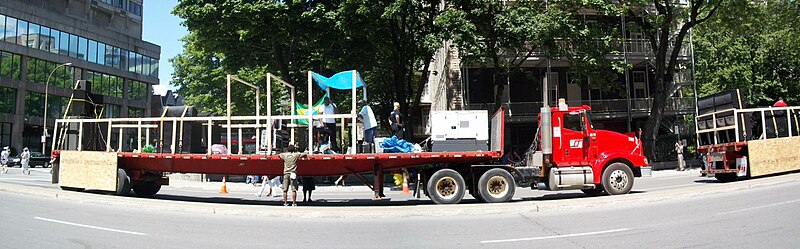 Um dos caminhões usados ​​no Carifête.  A plataforma carrega um gerador na frente e alto-falantes na parte traseira.