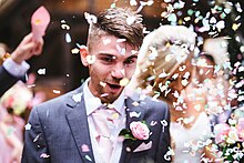 Paper confetti being thrown at a wedding in the United Kingdom Confetti on groom at Ash Vale (Unsplash).jpg