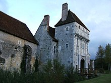 Farbfoto eines quadratischen Turms mit Machikolationen.