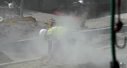 Workers in a cloud of concrete dust containing respirable crystalline silica with no controls in place.
