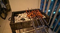 Grilling kebabs in Adana on a charcoal grill.