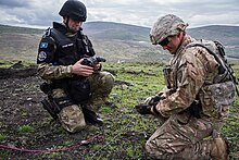 U.S. Army Staff Sgt. assists a member of the Kosovo Police Bomb Squad with the detonation cord for a demolition range in Rahovec. Kosovo Police Bomb Squad.jpg