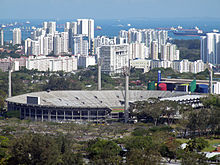 The former National Stadium in 2009. Leisure Park Kallang is seen on the right, the residential precinct at Kampong Kayu Road is seen in the distance, and the Singapore Straits is seen in the background. NationalStadium.jpg