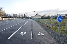 Piste cyclable avec, en arrière-plan, la route départementale