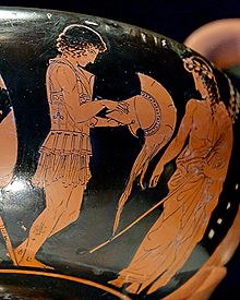 Paris (on the left) putting on his armour as Apollo (on the right) watches him. Attic red-figure kantharos, 425 - 420 BC Paris armour Pomarici Santomasi.jpg