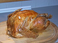 A roast turkey prepared for a traditional U.S. Thanksgiving meal. The white plastic object in the breast is a pop-up thermometer. Thanksgiving Turkey.jpg