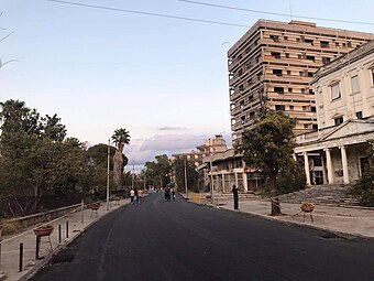 A newly paved road, Democracy Street, and abandoned buildings after reopening in 2020 (the white building to the right is the old school of art)
