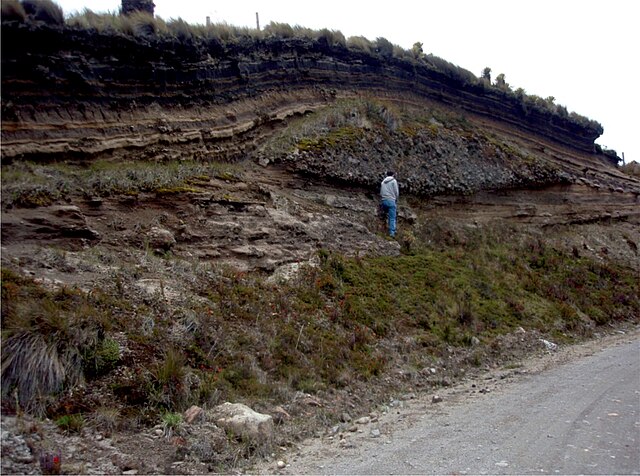 The top of the 11,000 year-old ash fall deposits interstratified with paleosols overlying a channelized debris flow and a sequence of wet surges