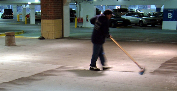 A worker sweeping floor of a parking garage in Atlanta.