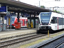Hinter dem Bahnsteig Regional­bahn nach Singen, rechts Zug der S-Bahn St. Gallen