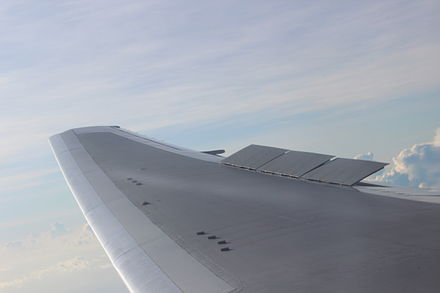 A view of the right wing of a Boeing 767-300ER during descent with spoilers partially deployed.