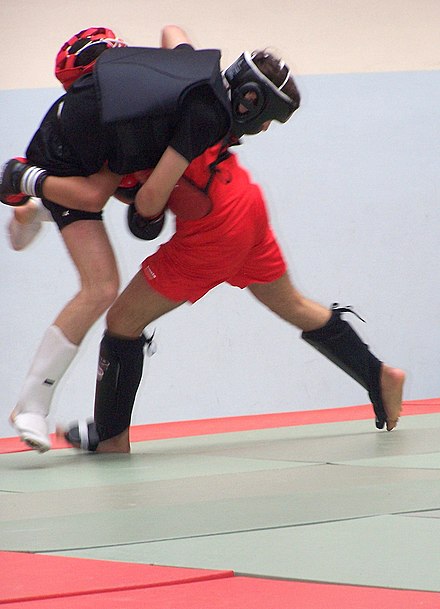 Sanda fighter attempts a double leg takedown on his opponent. Uniquely among kickboxing styles, Sanda allows fighters to perform takedowns and throws