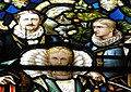 1875–1880 neo-Gothic stained glass window above staircase, featuring portraits of Butterfield family in 16th century costume.