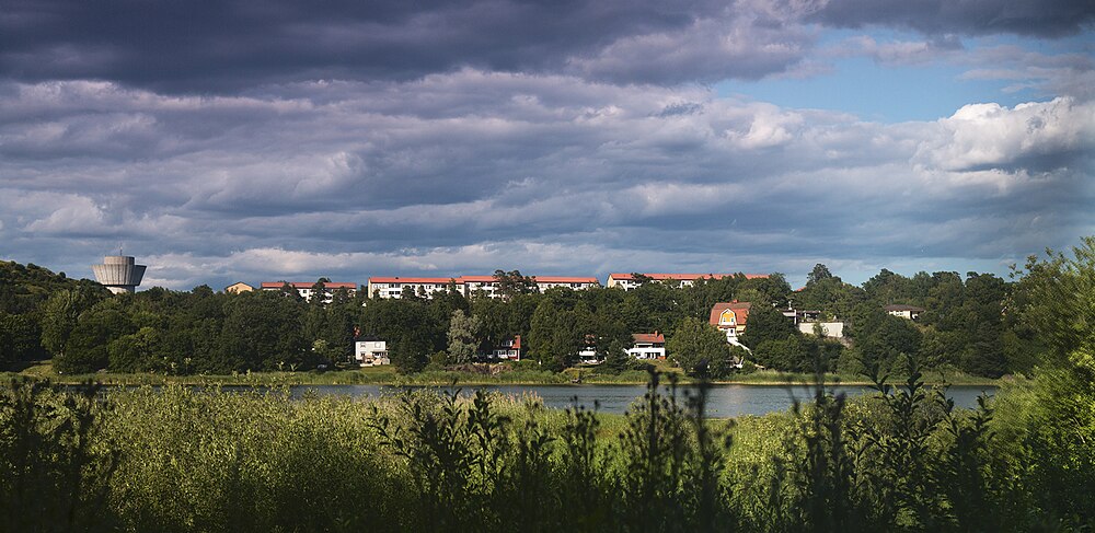 Husen på Gräsandsvägen i Fagersjö, med sjön Magelungen i förgrunden och Högdalsreservoaren på vänster sida, sommaren 2013.