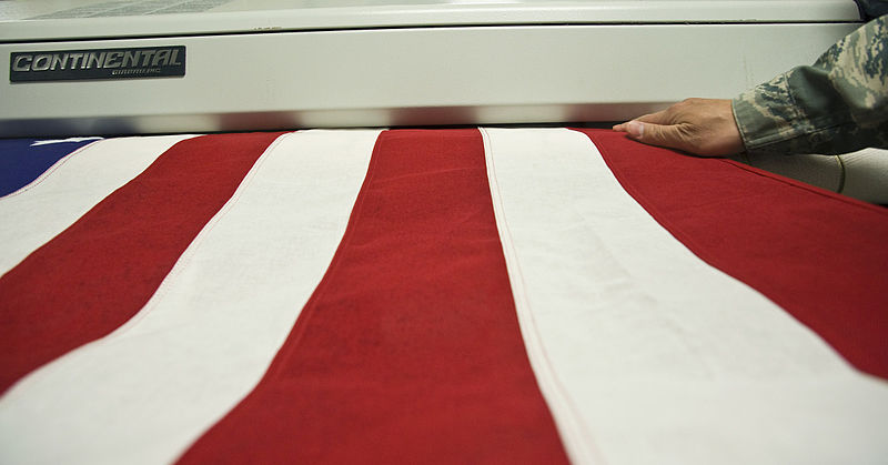 File:Feeding a U.S. flag into a pressing machine horizontal.jpg