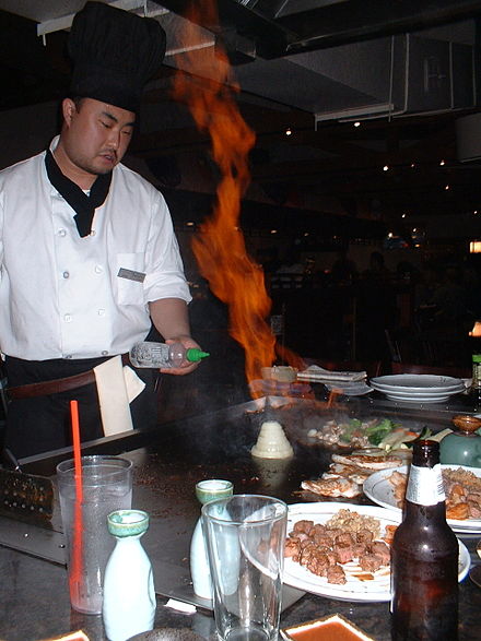 Chef preparing a flaming onion volcano